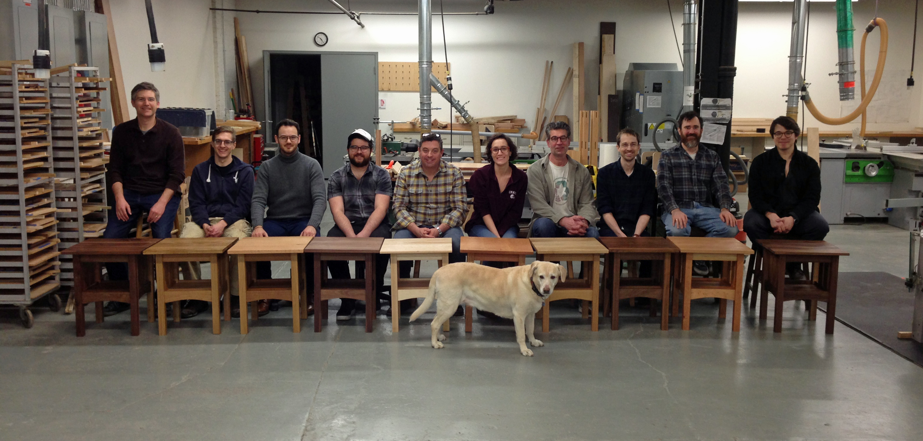 Students displaying their work with shop dog.